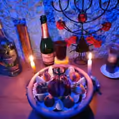 Oferenda com velas acesas e taças sobre um altar.